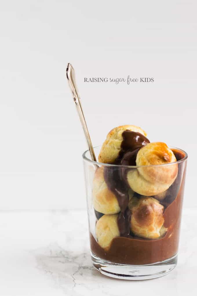 Low Sugar Profiteroles | Raising Sugar Free Kids - this is THE best thing I have ever made. Without doubt. The perfect low sugar Easter treat. Light as air choux pastry filled with sugar free creme patissiere and drowned in a low sugar chocolate fudge sauce which I am still dreaming about, by the way. Who says a low sugar Easter can't still be a great and delicious one? :) #sugarfree #lowsugar #easter #chocolate