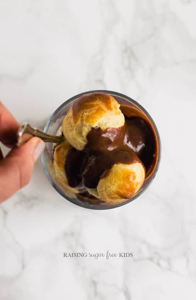 Low Sugar Profiteroles | Raising Sugar Free Kids - this is THE best thing I have ever made. Without doubt. The perfect low sugar Easter treat. Light as air choux pastry filled with sugar free creme patissiere and drowned in a low sugar chocolate fudge sauce which I am still dreaming about, by the way. Who says a low sugar Easter can't still be a great and delicious one? :) #sugarfree #lowsugar #easter #chocolate